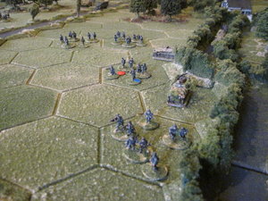 German infantry sections advance in the open ground next to the bocage lane